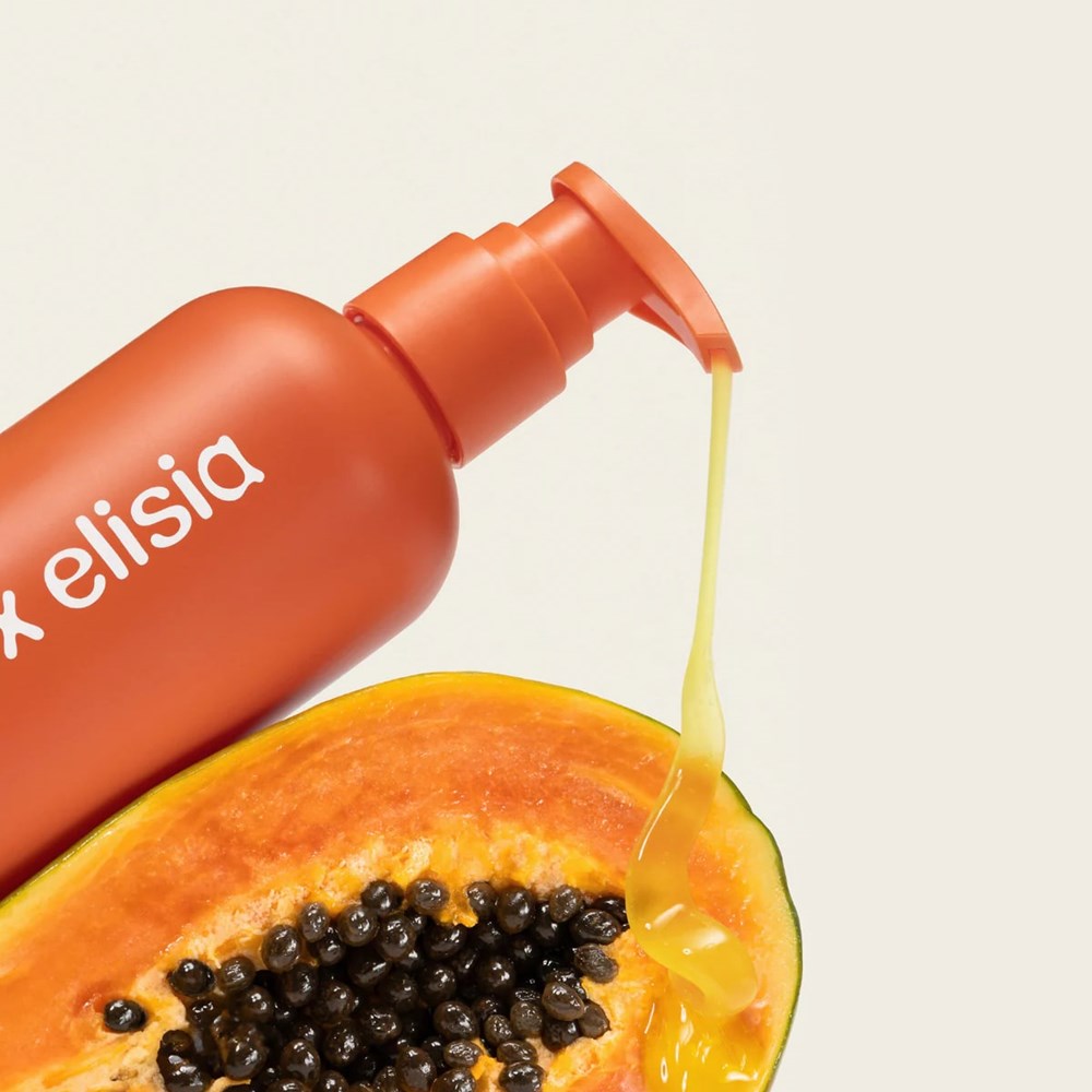 Elise x Elisia Papaya Glow Nectar Body Wash (9.4 oz) poured onto a halved papaya on a beige background
