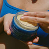 Ursa Major Golden Hour Body Butter (6.7 oz) - person dipping fingers into product pot