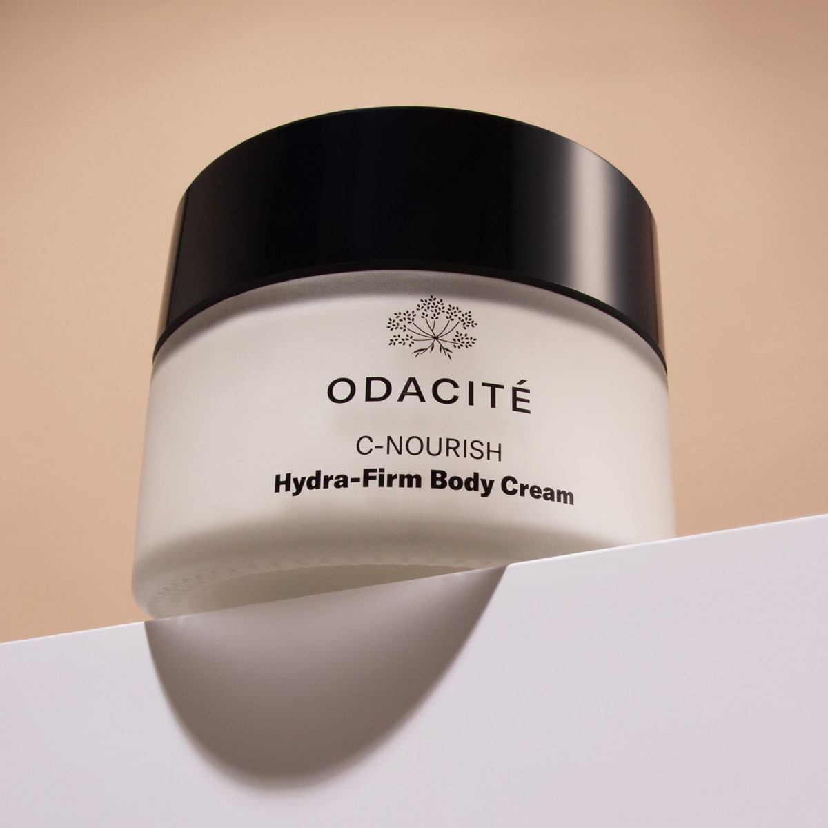 Odacite C-Nourish Hydra-Firm Body Cream (6 oz) - product shown on resting on ledge 
