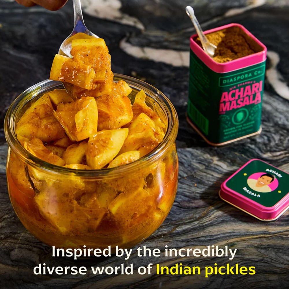 Diaspora Co Nik's Achari Masala (1.9 oz) - product shown open with a spoon in the jar next to a jar of pickles with a fork