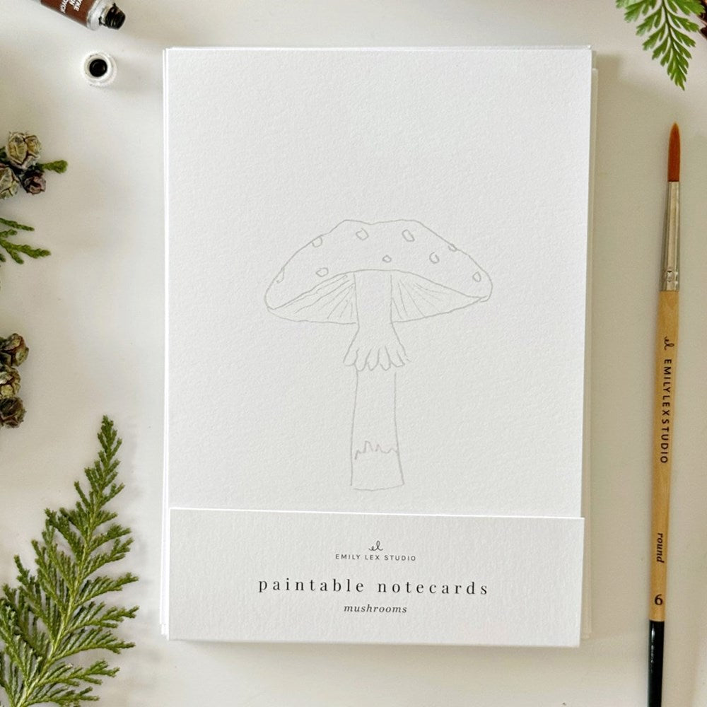 Emily Lex Studio Mushrooms Paintable Notecards (8 pcs) - product shown on white background with fern leaves and paintbrush. 