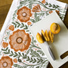 Peach on cutting board with close up of Gingiber Poppy Tea Towel (1 pc)