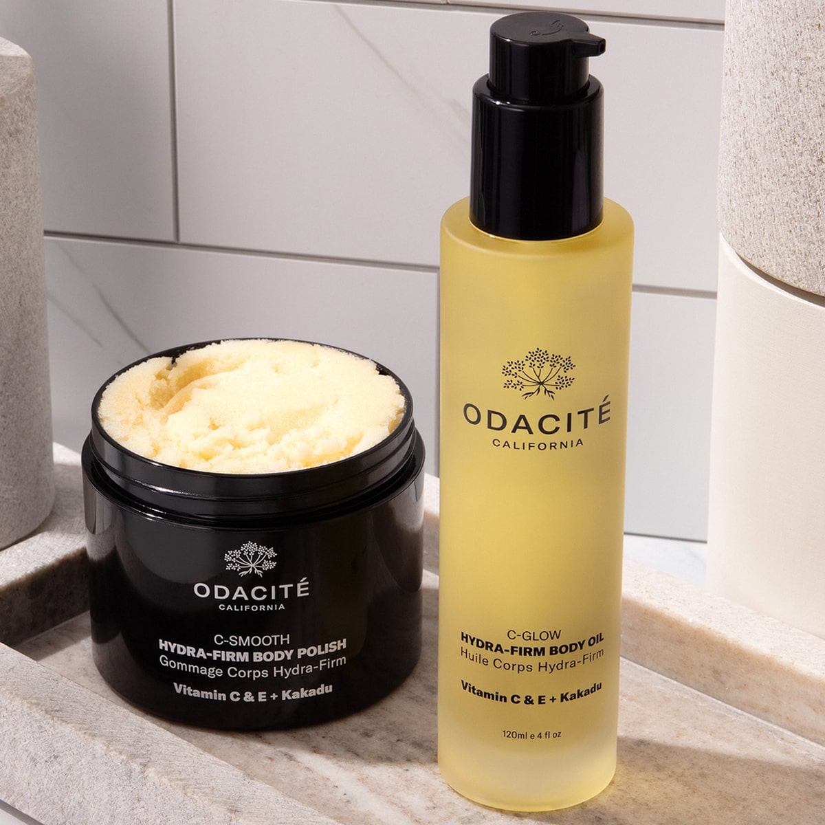 Odacite Smooth + Glow Vitamin C Body Essentials Set (2 pc) - products shown on bathroom counter. 