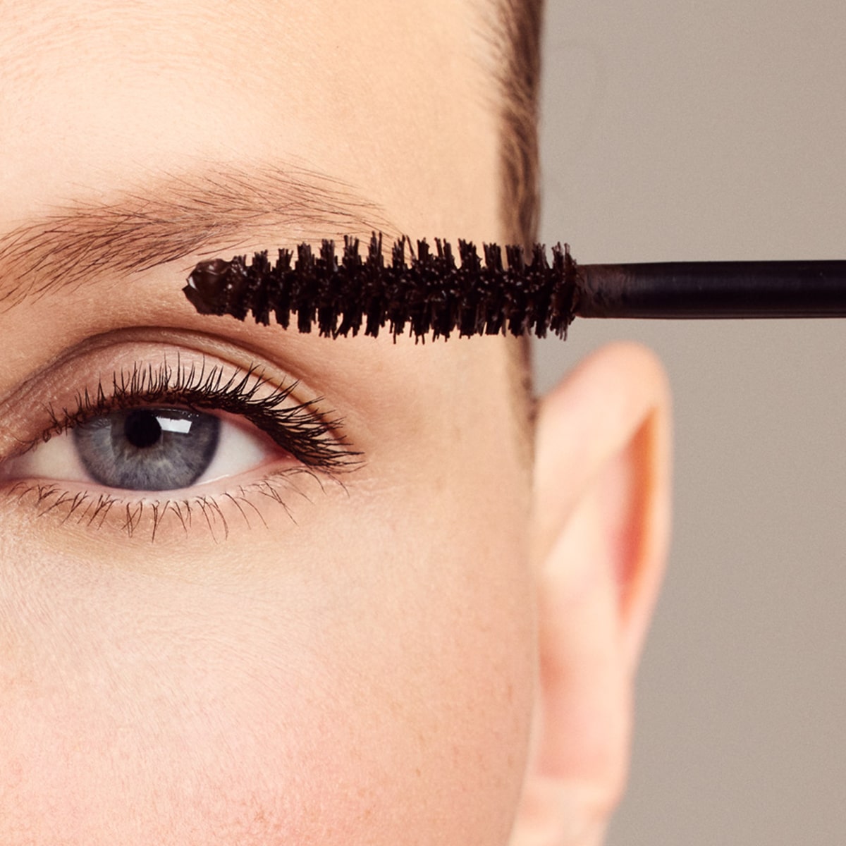 Close up of model applying Dr. Hauschka Long Lasting Mascara - Brown 02 to eyelash