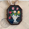 Maris Mirum Small Locket - Tulips in Urn (1 pc) on an aged envelope background with a stamp