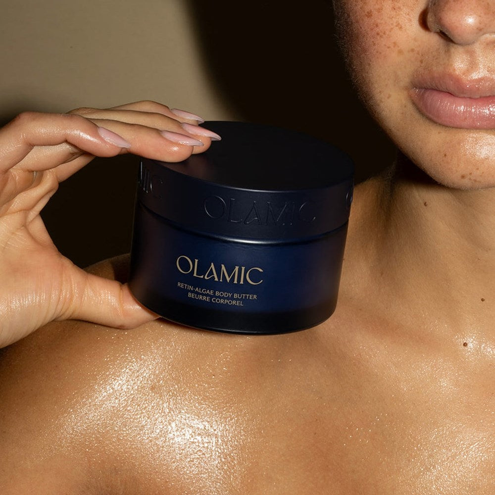 Olamic Retin-Algae Body Butter (6.7 oz) - model holding product near collarbone. 