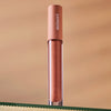 Lifestyle shot of Minori Lip Gloss - Cozy (3.5 ml) sitting on glass shelf