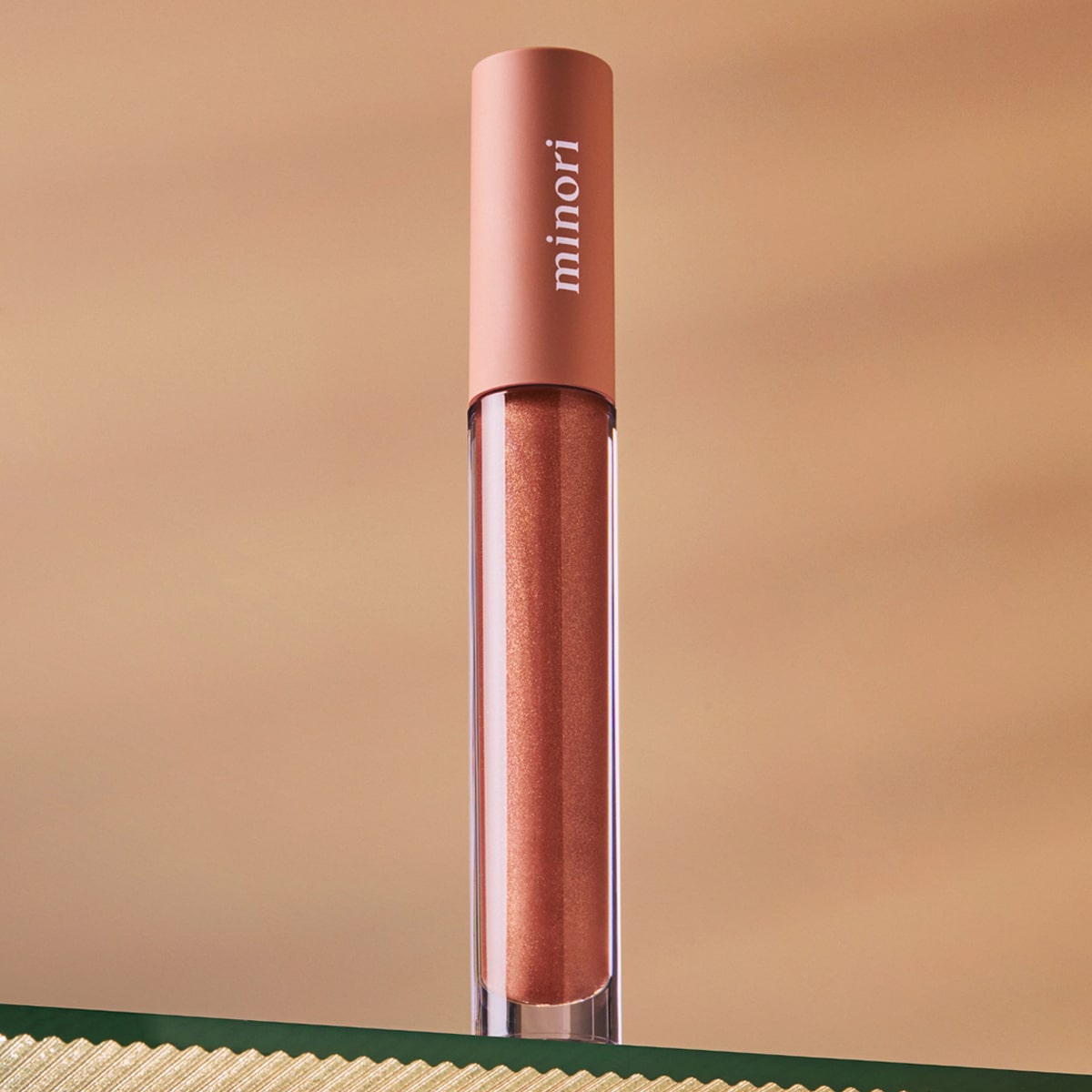 Lifestyle shot of Minori Lip Gloss - Cozy (3.5 ml) sitting on glass shelf