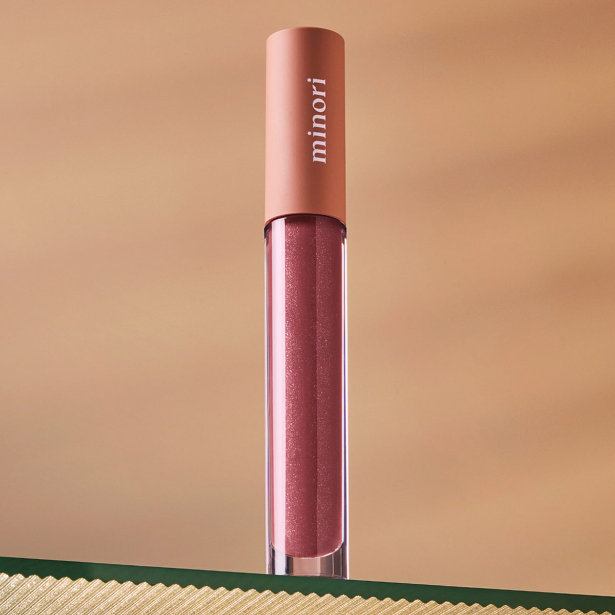 Lifestyle shot Minori Lip Gloss - Juneberry (3.5 ml) sitting on glass shelf