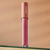 Lifestyle shot of Minori Lip Gloss - Blossom (3.5 ml) sitting on glass shelf