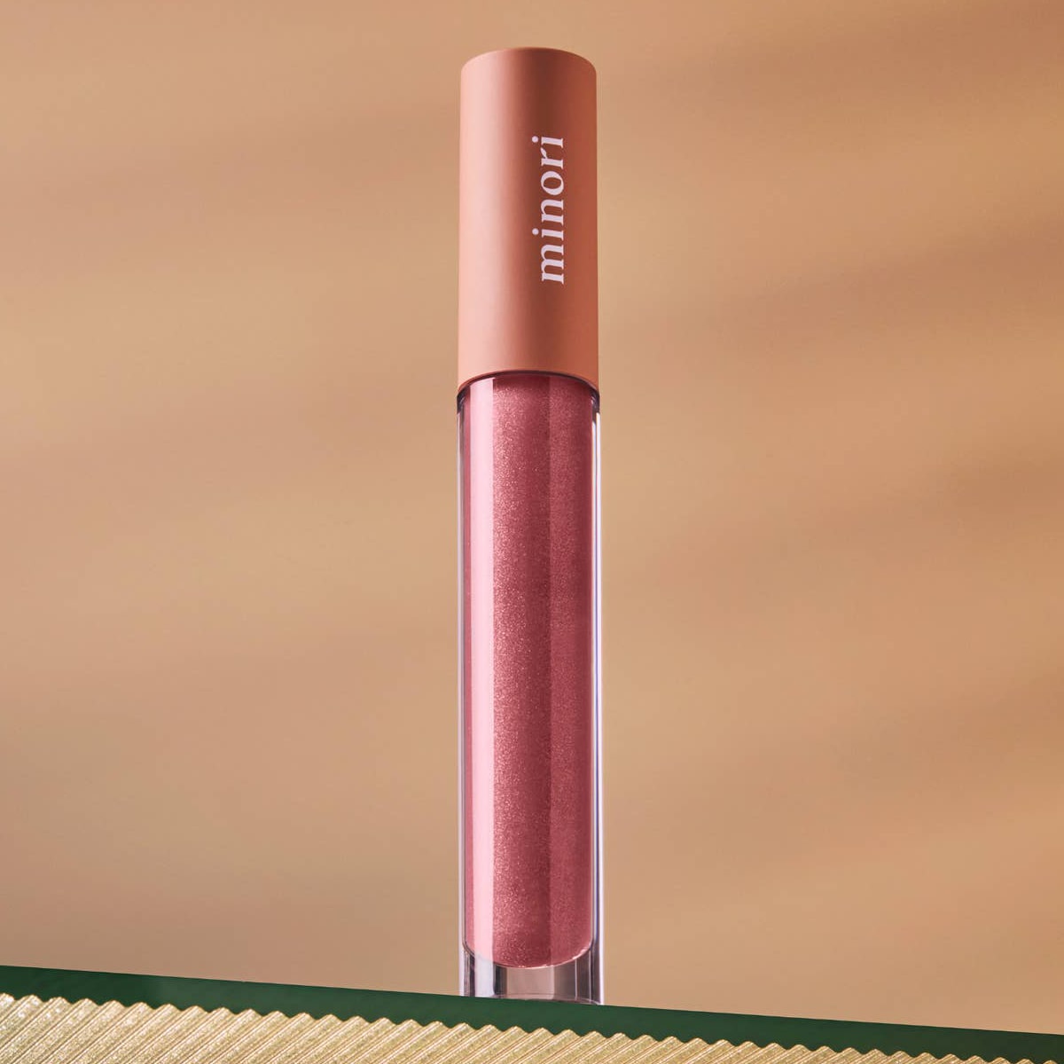 Lifestyle shot of Minori Lip Gloss - Blossom (3.5 ml) sitting on glass shelf