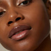 Close up of model with dark complexion wearing Minori Lip Serum - Dream