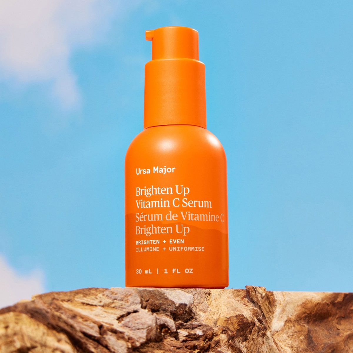 Ursa Major Brighten Up Vitamin C Serum (1 oz) - product shown on bright blue background and wood. 