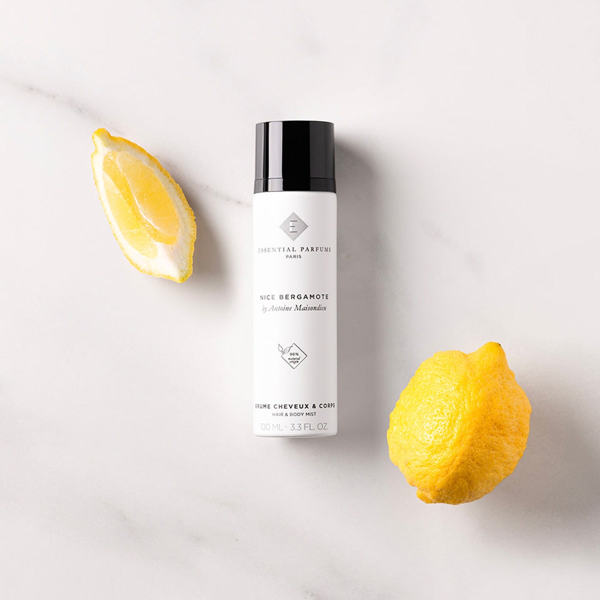 Essential Parfums Nice Bergamote Hair & Body Mist (100 ml) - product shown next to lemons. 