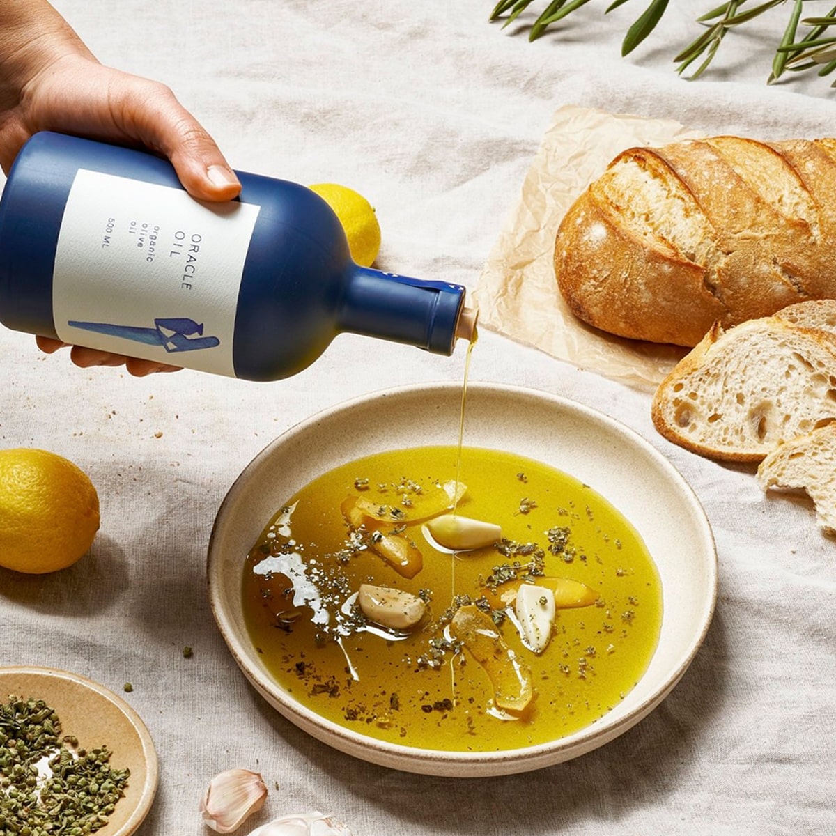 Oracle Oil Olive Oil (500 ml) - product shown being poured into a bowl with other ingredients (ingredients not included).