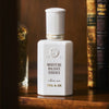 Paul & Joe Beaute Moisture Balance Essence (60 ml) - product shown with books on wood shelf. 