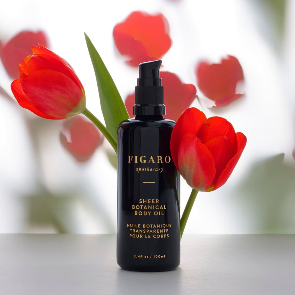 Figaro Apothecary Sheer Botanical Body Oil (3.4 oz) with red tulips in the background