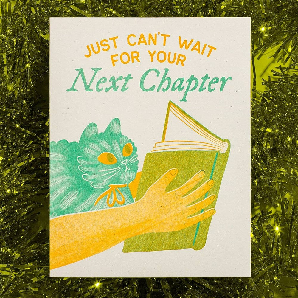 Bromstad Printing Co. Next Chapter Greeting Card (1 pc) - product shown on green sparkly tinsel. 