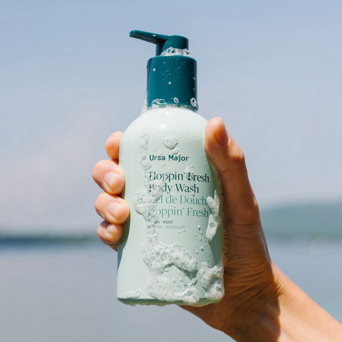 Model holding Ursa Major Hoppin’ Fresh Body Wash (10 oz)
