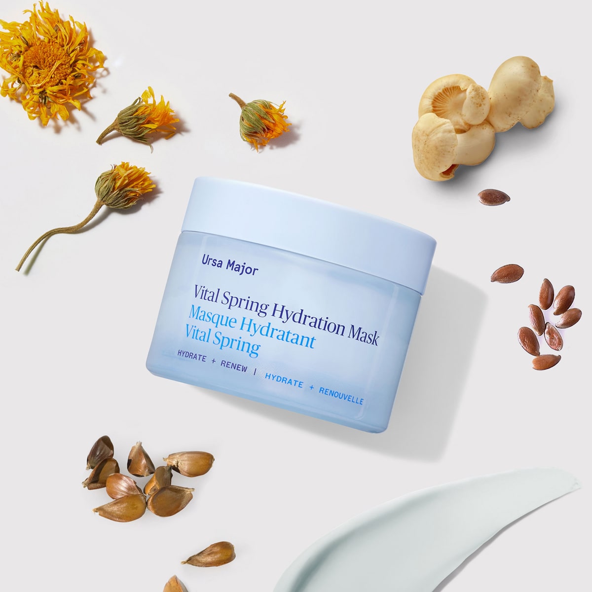 Lifestyle shot of Ursa Major Vital Spring Hydration Mask (1.69 oz) with ingredients in the background