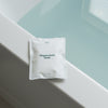 Mother Mother Magnesium Bath Soak – Single Soak (3 oz) - product shown on edge of bathtub. 