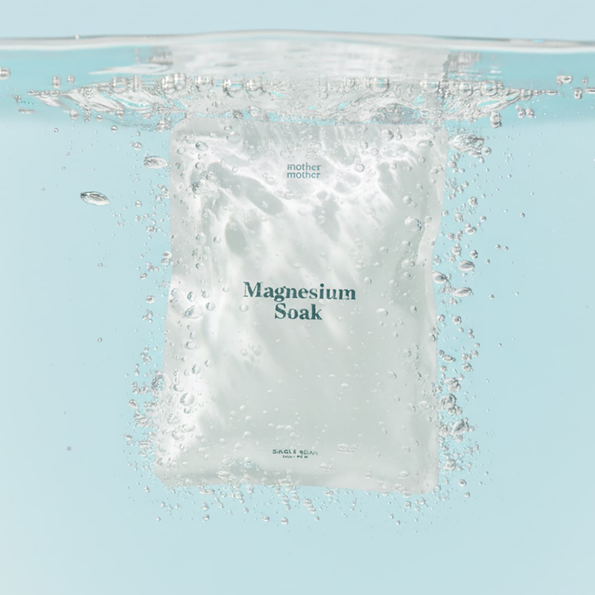 Mother Mother Magnesium Bath Soak – Single Soak (3 oz) - product shown in packaging under water. 