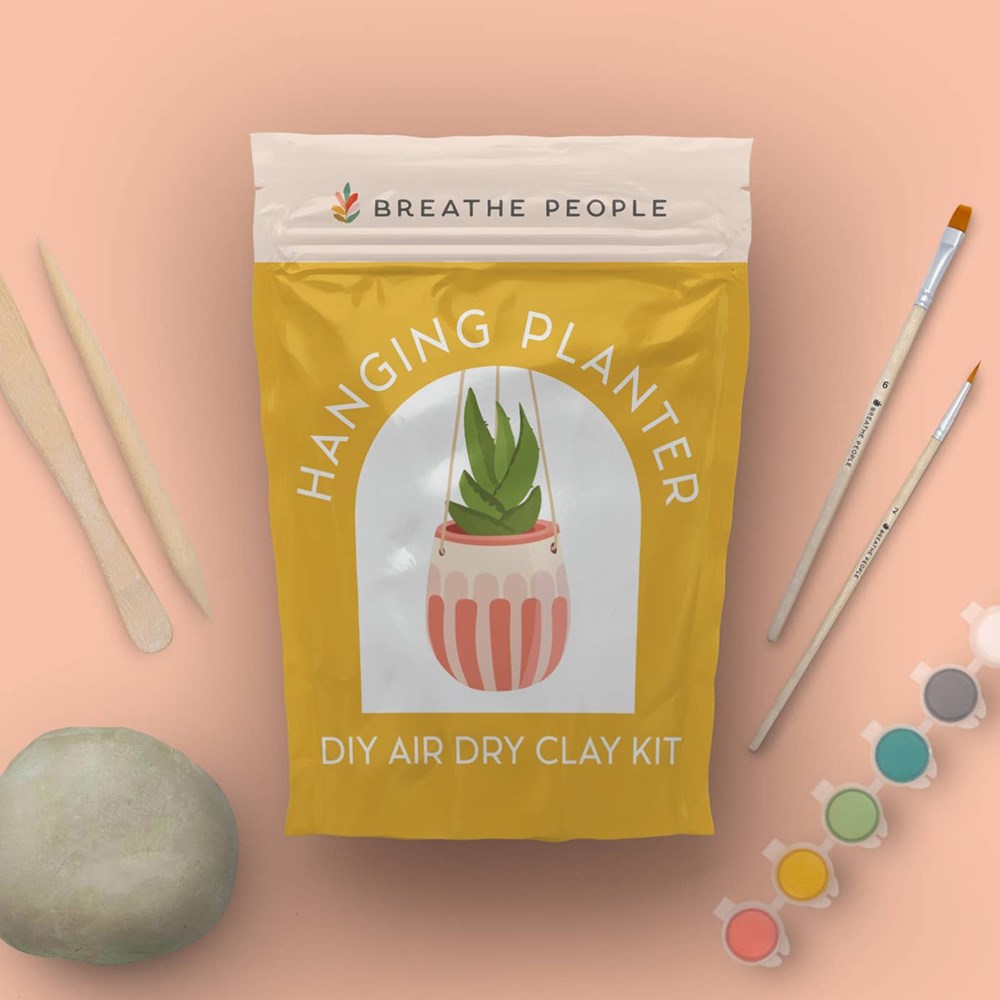 Breathe People DIY Air Dry Clay Kit - Make Your Own Hanging Plant Pot (1 kit) - product shown on salmon background with supplies around it.