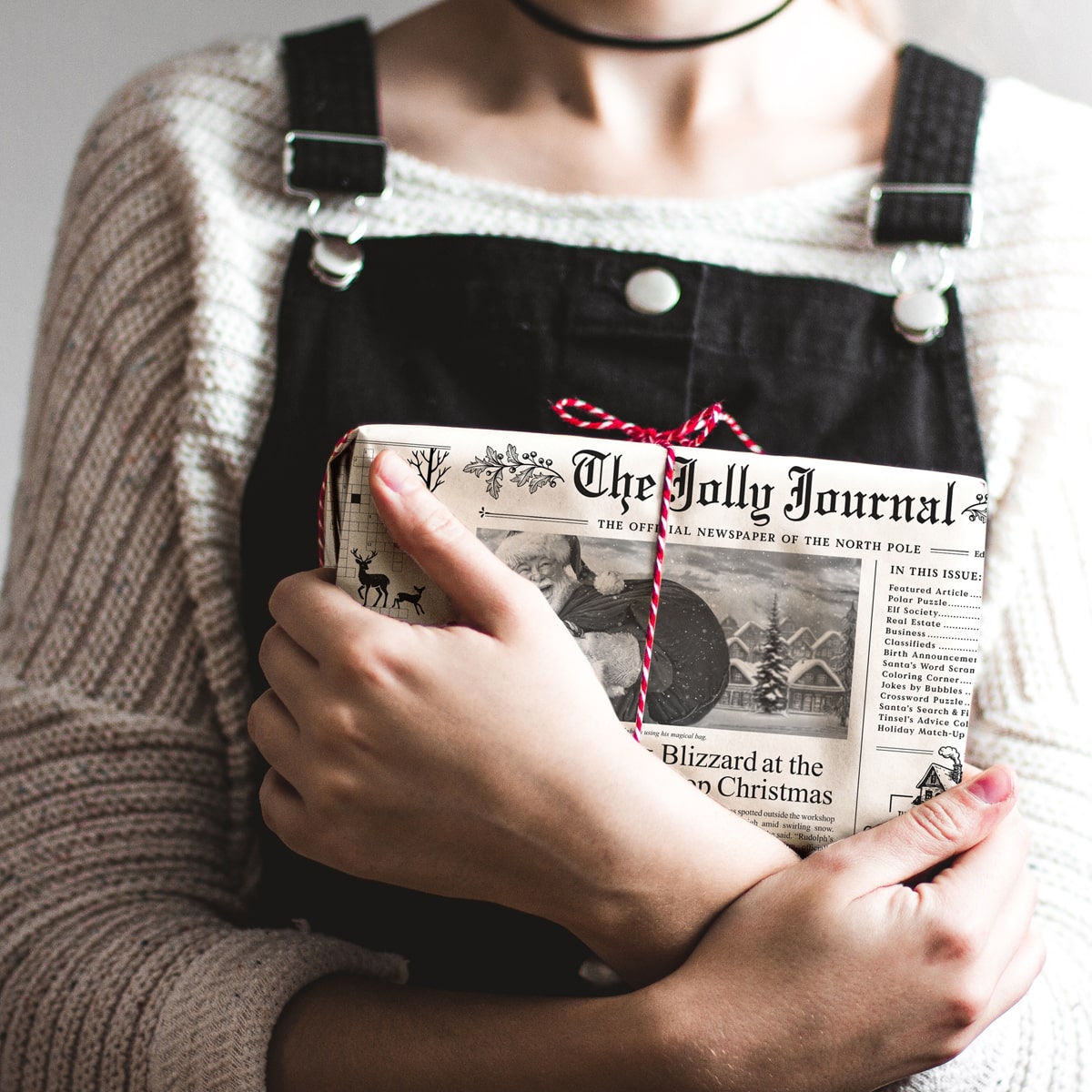Inklings Paperie The Jolly Journal Newspaper Gift Wrap (4 pcs) - product shown with red bow being held by person. 