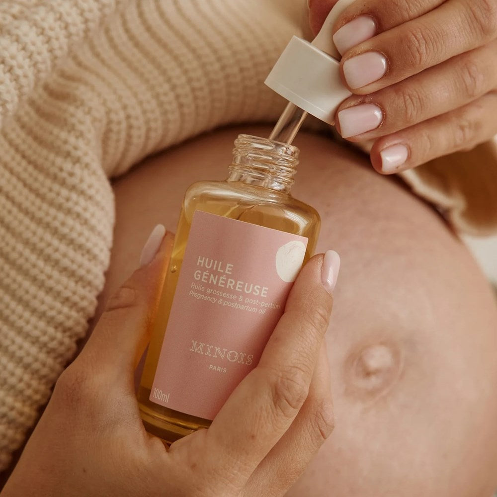 Minois Paris Mama Generous Body Oil (100 ml) - product shown being held by hands. 
