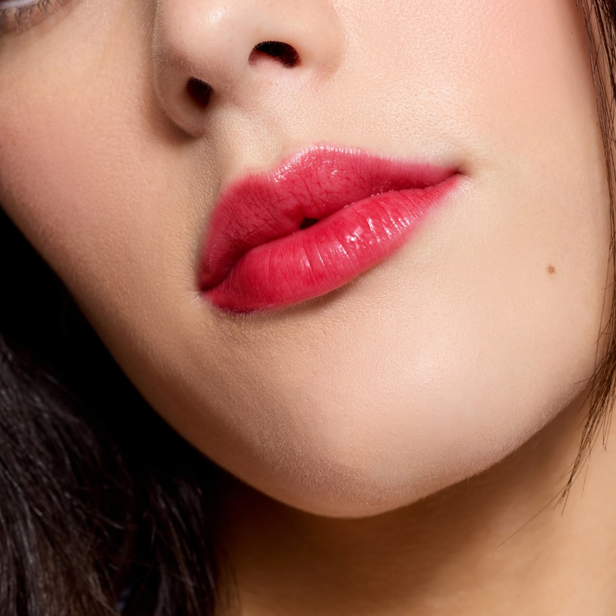 Cote The Necessity Peptide Lip Shine - Tempted (3.5 ml) - product shown on model.