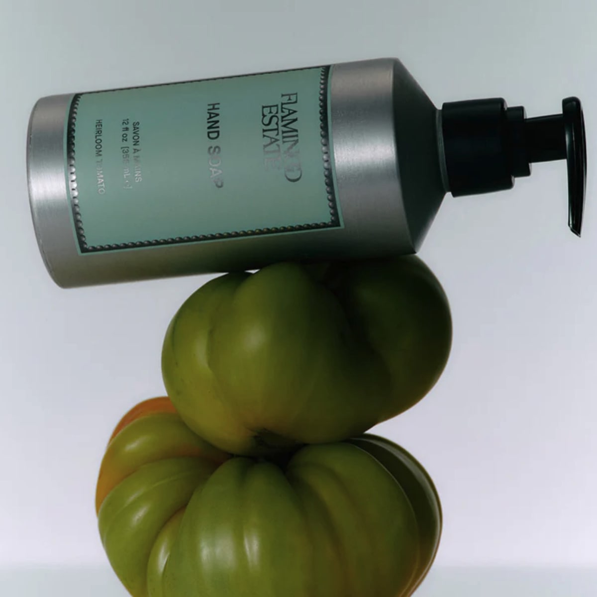 Flamingo Estate Organics Heirloom Tomato Hand Soap (355 ml) - product shown on top of tomatoes. 