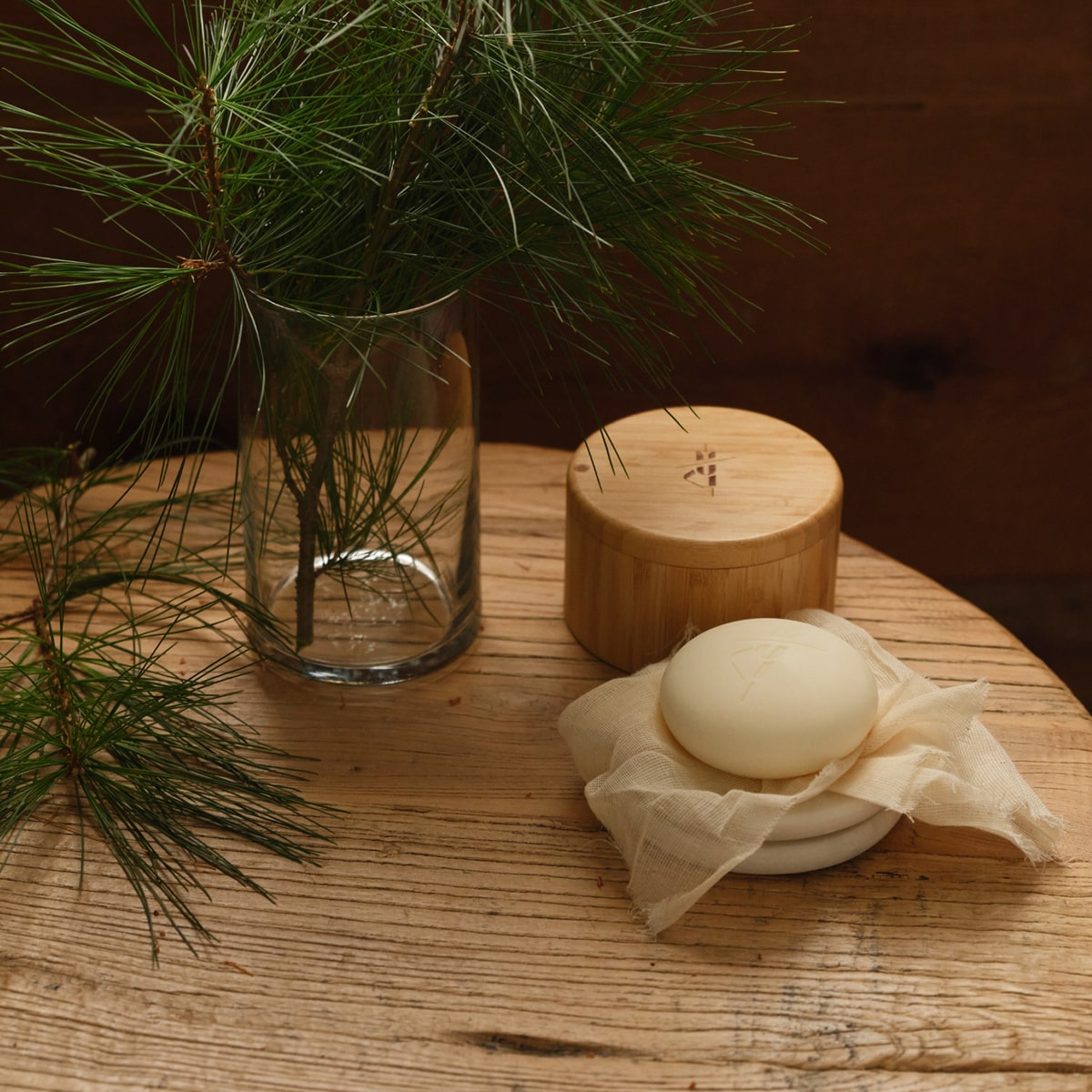 Kate McLeod Black Spruce & Patchouli Deep Moisturizing Lotion Bar (3.5 oz) - product shown on wooden table with a cloth. 