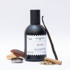 Perfumerica Milan Eau de Parfum (120 ml) - product shown next to vanilla and wood. 