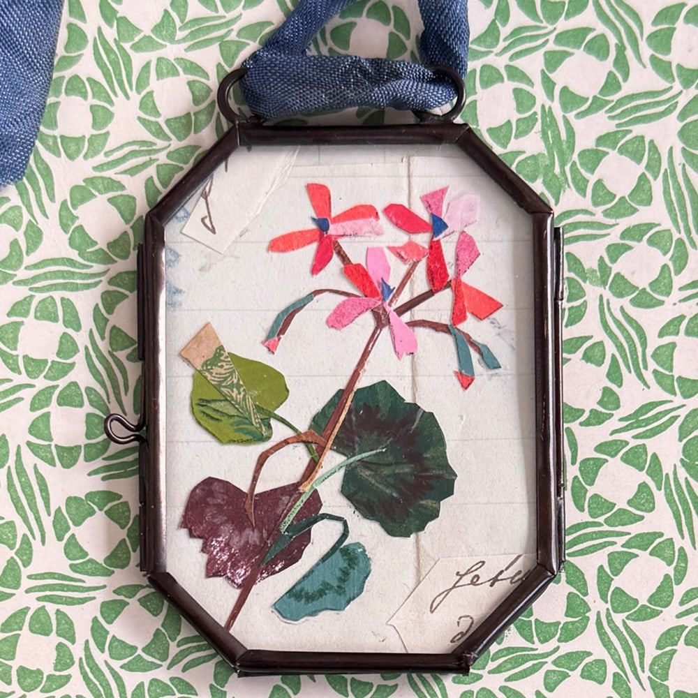 Maris Mirum Small Locket - Geranium No. 1 (1 pc) with green and white patterned paper in the background