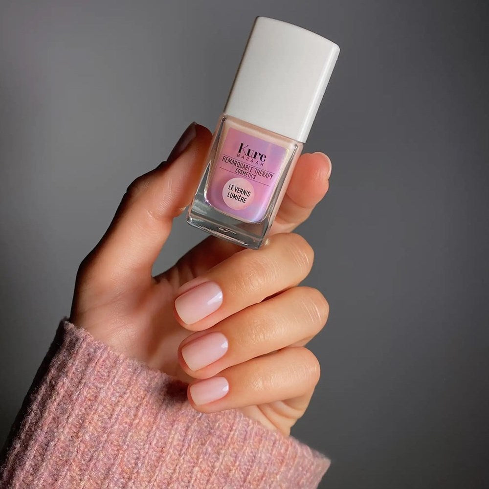 Kure Bazaar Vernis Lumière - Illuminateur Rose (10 ml) - product shown being held up. 