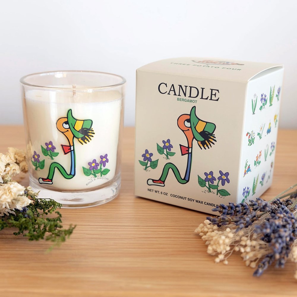 Three Potato Four 3P4 X Richard Scarry Candle - Lowly Worm (6 oz) on a wooden surface with dried flowers in the foreground