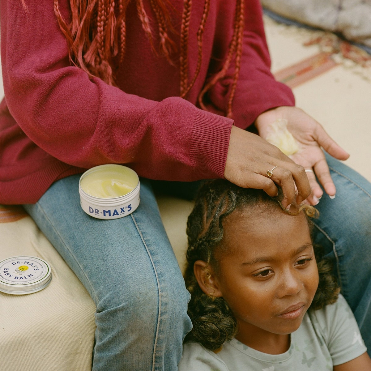 Dr. Max’s Baby Balm (3.3 oz) - product being applied to child's forehead. 