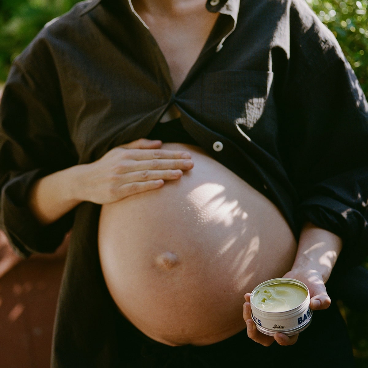 Dr. Max’s Baby Balm (3.3 oz) - product being applied to pregnant woman's belly. 