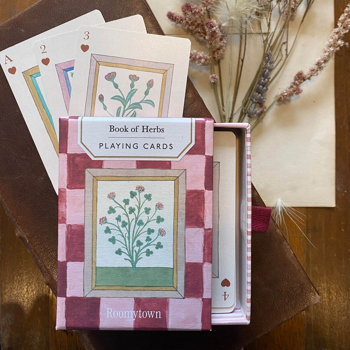 Roomytown Inc Book of Herbs Playing Cards (1 set) - product shown on wooden table. 