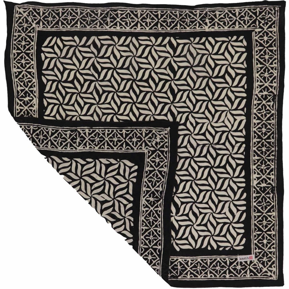 Kasih Co-op Hand Dyed Batik Bandana - Onyx Pinwheel (1 pc) shown folded at the corner