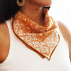 Model wearing Kasih Co-op Hand Dyed Batik Bandana - Mustard (1 pc) around neck