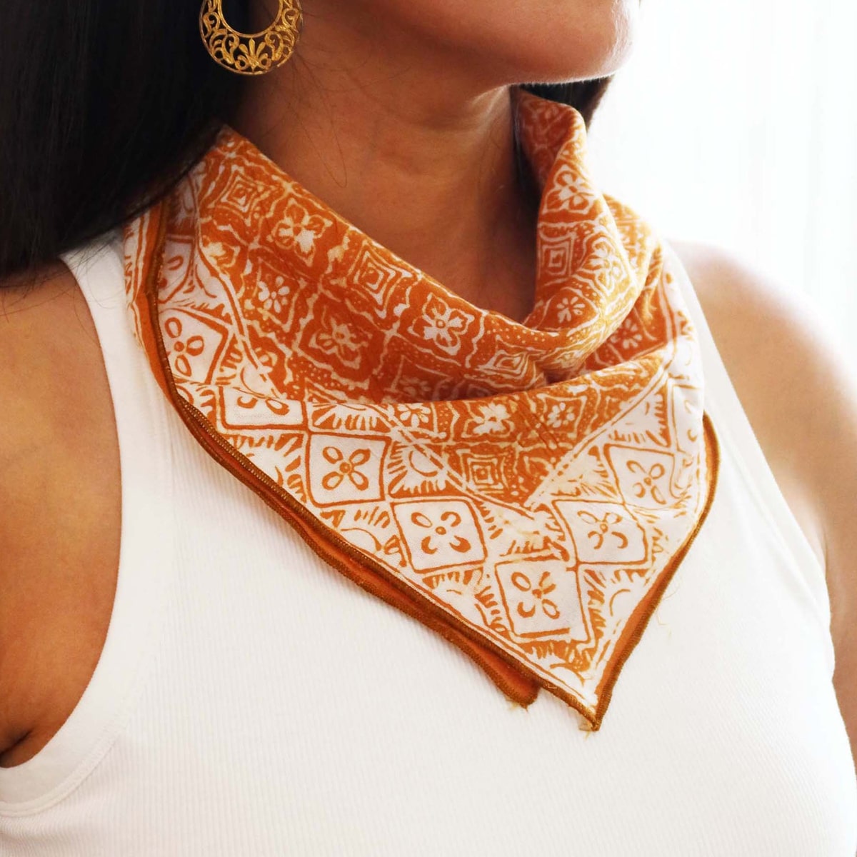 Model wearing Kasih Co-op Hand Dyed Batik Bandana - Mustard (1 pc) around neck