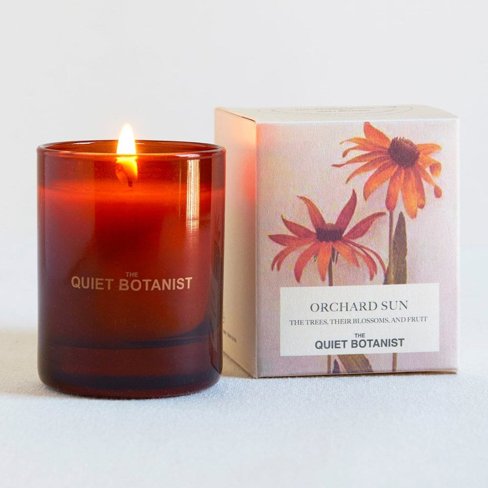The Quiet Botanist Orchard Sun Mini Candle (3 oz) - product shown next to packaging. 