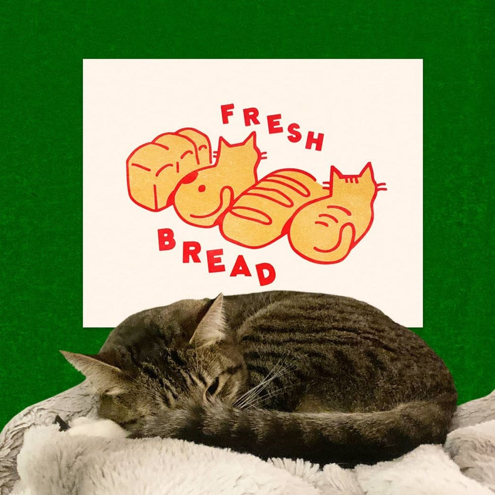 Pencil & Post Fresh Bread Riso Print (1 pc) - product shown on green background with cat in front of it.