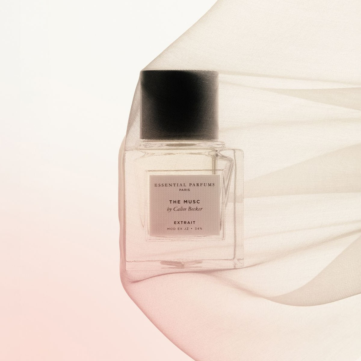 Essential Parfums The Musc Extrait De Parfum by Calice Becker (30 ml) with sheer fabric covering bottle against a soft pink background