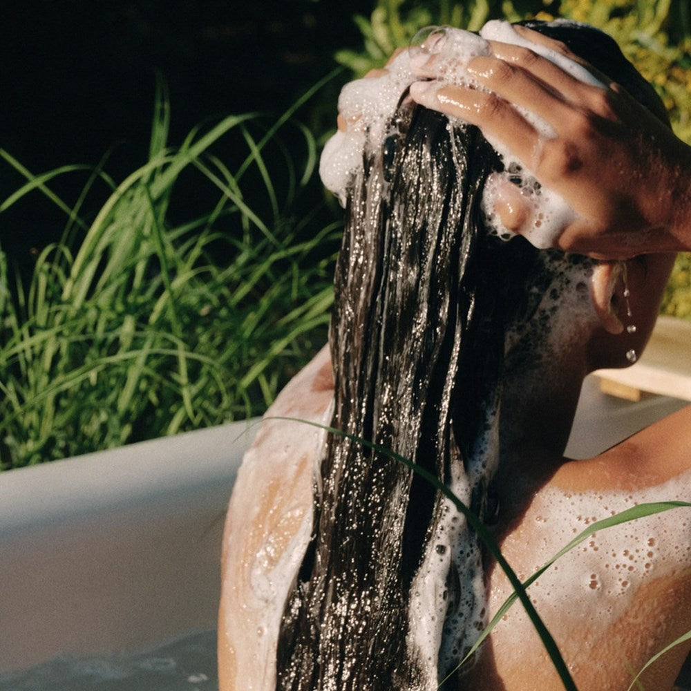 Roz SALT Scalp Scrub (200 ml) - product shown being lathered on brown hair. 