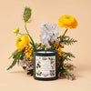 Rifle Paper Co. High Peaks of the Adirondack Forest Glass Candle (9.5 oz) with flowers in the background