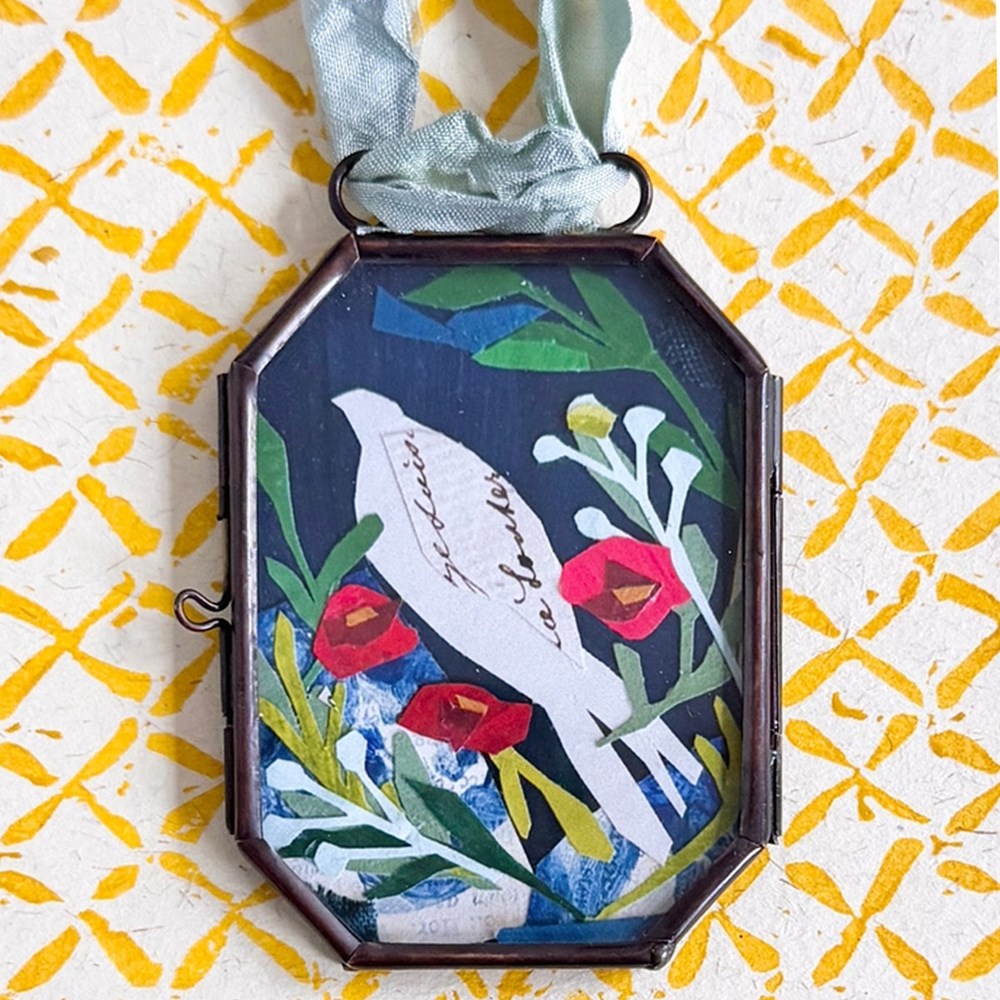 Maris Mirum Small Locket - Rose Dove (1 pc) on a yellow and white patterned paper