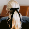 Grace & Grandeur Alice Long Velvet Bow - Black (1 pc) - product shown in women's hair. 