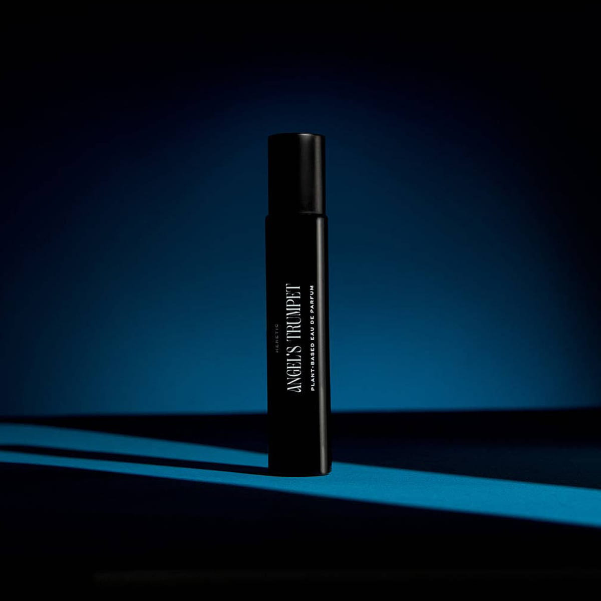 Heretic Parfum Angels Trumpet Eau de Parfum (15 ml)  - product shown on black background with blue light. 